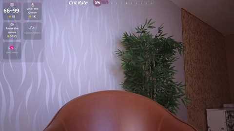 Media: A photograph of a modern room with a beige leather chair, a green potted plant, and textured wallpaper. A digital screen displays financial data and a chart, suggesting a financial setting.