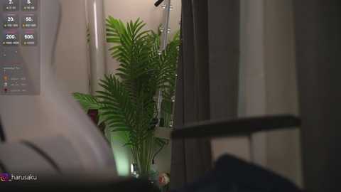 Media: Video of a dimly lit hospital room with a green potted plant, medical equipment, and a white wall. A chart with percentages is visible in the background.