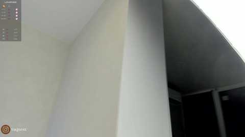 Media: A video of an interior corner, featuring a smooth, white wall and a dark, angled ceiling. The left side is well-lit, while the right side is dimly lit, creating a shadow effect. The bottom left corner has a watermark with the text \"Play Music.\