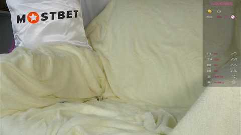 Media: Video of a messy bed covered in white sheets, with a \"MOSTBET\" pillow and a partially visible person's leg.