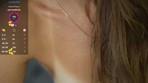 Media: Video of a close-up of a woman's bare shoulder and upper arm with a thin gold chain necklace, showing tan lines and a light skin tone.