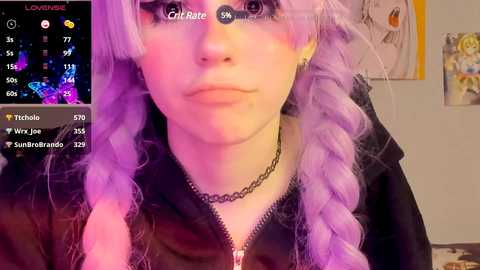 Media: Video of a pale-skinned woman with long, lavender braided hair, wearing a black hoodie and choker, captured in a dimly lit room with a smartphone interface overlay.