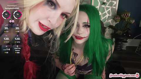 Media: Video of two women with vibrant hair (one blonde, one green), wearing gothic makeup and lingerie, in a dimly lit room, with a \"HentaiPanties\" watermark.