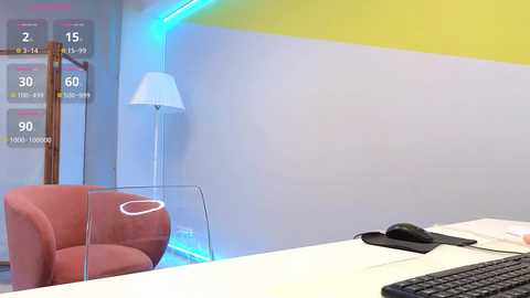 Media: Video of a modern office with a white desk, red chair, and glass partition; blue and yellow accent walls; white floor lamp; keyboard on desk; digital clock display.