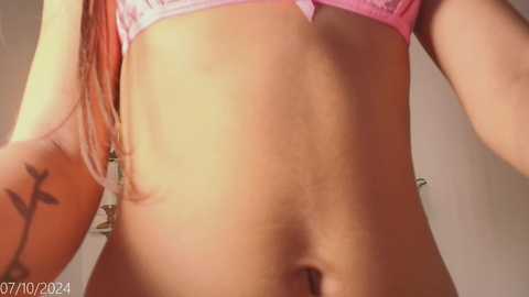 Media: A close-up video of a light-skinned woman in pink lace lingerie, revealing her flat stomach and pubic area. The image is slightly blurred, with a watermark at the bottom left corner.