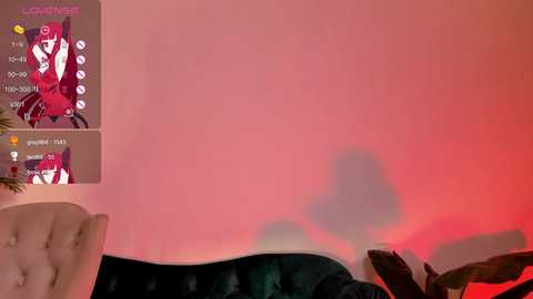 Media: A video featuring a plush, dark green velvet chaise lounge with a shadowy figure and a digital game screen displaying a red background and character selection.