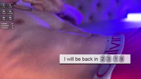 Media: A video showing a close-up of a muscular, tattooed man's torso, wearing red underwear, with a purple light illuminating his skin. Text overlay reads, \"I will be back in 2:3 1:9.\