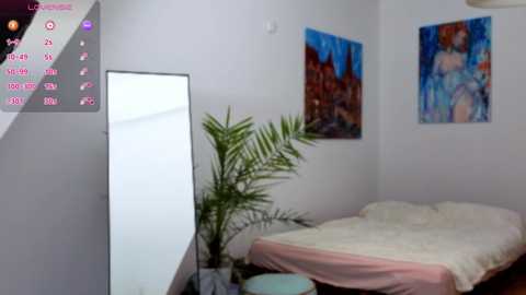 Media: Video of a minimalist, modern bedroom with a white bed, a tall mirror, green plant, and two vibrant abstract paintings on white walls.