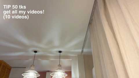 Media: A video of a modern room with beige walls, a textured ceiling, and two hanging pendant lights. Text in the top left reads, \"TIP: 50 kgs get all my videos! No videos.\