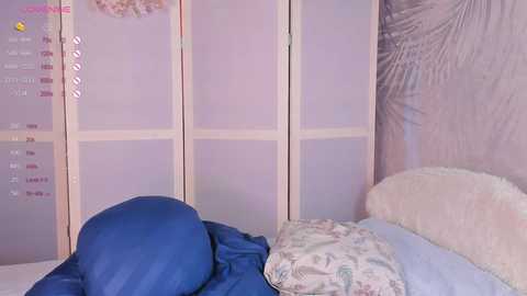 Media: A video of a serene, minimalist bedroom with a cream-colored headboard, blue bedding, and soft, pastel-colored walls featuring a palm leaf design. A calendar with purple and pink text is visible on the left.