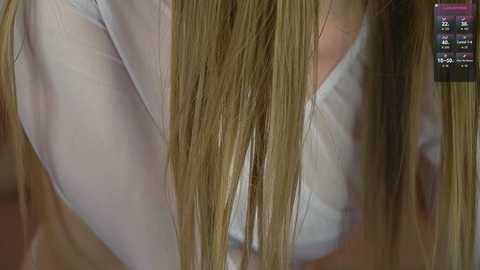 Media: A close-up video shows a woman's bare back and shoulder, with long, straight, blonde hair partially covering her white blouse. The background is blurred, and a weather app with the date and temperature is visible in the top right corner.