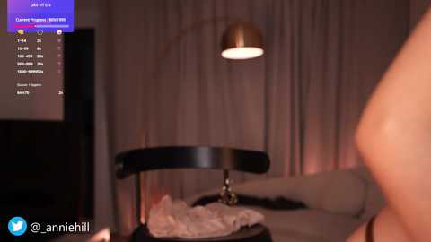 Media: A video of a dimly lit bedroom with a woman's naked torso visible, a black lampshade, and a partially visible bed with white sheets.