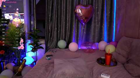 Media: Video of a dimly lit bedroom with a TV displaying a sports game, grey curtains, a heart-shaped balloon, pastel balloons, a red cup, and a messy bed.