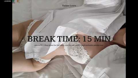 Media: Video of a woman lying on white sheets in a white lace bra, with the text \"Break Time: 15 Min\" overlaid.