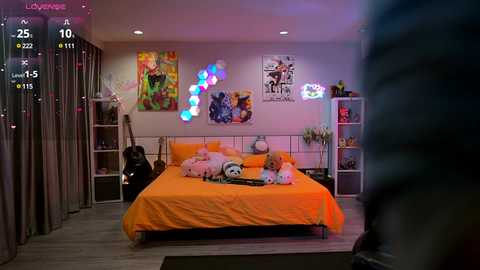 Media: Video of a vibrant, cozy bedroom with an orange bed, plush toys, colorful wall art, and a guitar on the floor, with a blurred person in the foreground.