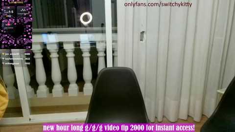 Media: Video of a modern, minimalist room with a black chair facing a window with white curtains, displaying a live stream of a Twitch channel \"switchkitty.\