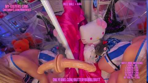 Media: A video of a plush-filled, neon-lit room with a large white bunny, a pole, and a blue and white striped outfit, featuring a wooden dildo.