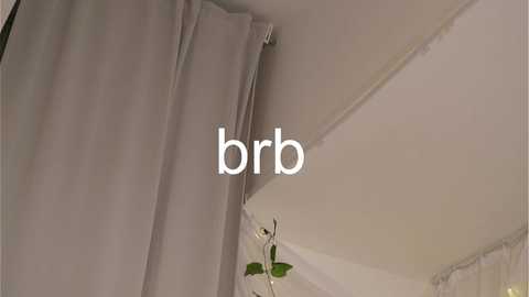 Media: A video shows a beige curtain hanging from a white ceiling, with \"brb\" text overlaid. The image has a neutral, minimalist aesthetic.