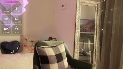 Media: A video of a cozy, well-lit room with a green armchair, plaid throw, heart-shaped pillows, and a large mirror with a floral painting, all set against soft pink walls.