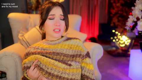 Media: A video depicts a young woman with brown hair, wearing a striped sweater, lying on a white couch, eyes closed, mouth open, and text overlay: \"I need to cum and fix my mood.\