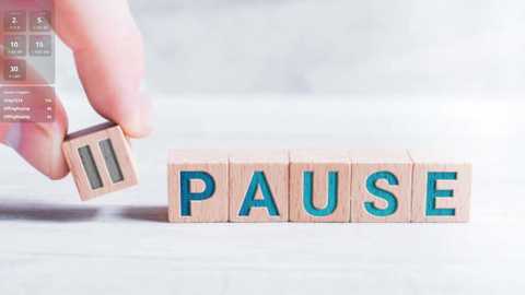 Media: A video of a hand holding wooden letter blocks with \"PAUSE\" written in blue, against a blurred white background.