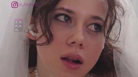 Media: A video of a young Asian woman with wet, curly hair, wearing a white veil, looking surprised and slightly open-mouthed.