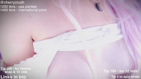 Media: Video of a close-up of a woman's upper body, wearing sheer white lingerie with lace trim, revealing cleavage. Text overlays include hashtags, tips, and a watermark.