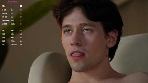 Media: A close-up video of a shirtless, fair-skinned young man with short brown hair, blue eyes, and slightly parted lips. He appears to be in a relaxed, casual setting.