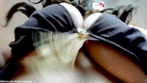 Media: A close-up video of a woman's breasts, with a focus on the nipple, showing detailed texture and slight movement. The background is blurry, with a blue and white theme.