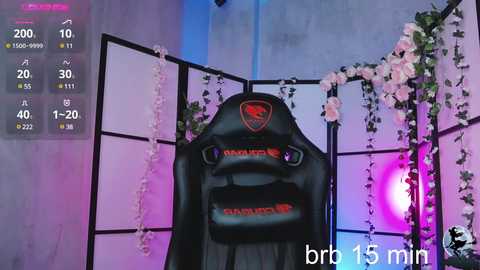 Media: Video of a black gaming chair with a red \"Dagger\" emblem, surrounded by pink and white floral garlands, set against a purple and blue backdrop, featuring a speedometer display of 15 minutes.