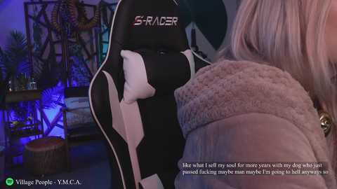 Media: A video shows a person in a gaming chair with a black and white \"S-Racer\" gaming headset, speaking in a dimly lit room with plants and a wooden shelf in the background.