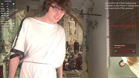 Media: A video captures a young man with curly hair, glasses, and a white robe, standing in a room with a Renaissance painting on the wall. The scene is overlaid with a YouTube Live video, displaying a chat and a video of a cat.