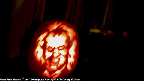 Media: Video of a carved pumpkin with a grimacing face, lit from within, against a dark background, by Hal T. Huang.