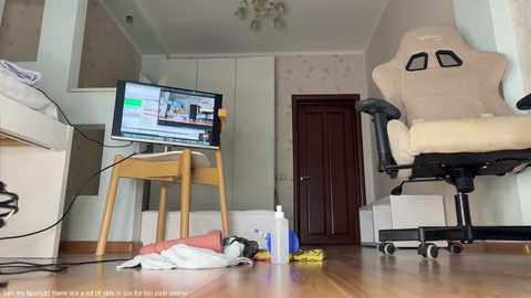 Media: Video of a cluttered living room with a desk, TV, gaming chair, and scattered cleaning supplies on the floor.