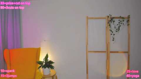 Media: Video of a minimalist living room featuring a mustard-yellow armchair, a small wooden table with a green plant, a wooden screen with ivy, and a pink digital overlay reading \"35-price-cut-on-top,\" \"30-spink-S-Jumps,\" and \"25-love-4lyga.\