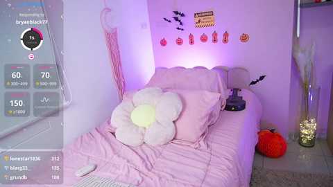 Media: Video of a pastel-themed, Halloween-decorated bedroom with a plush flower pillow, bat wall stickers, and a pumpkin on the floor.