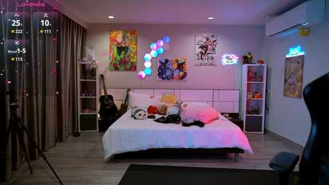 Media: Video of a colorful, modern bedroom with a white bed, neon lights, art, and a guitar.