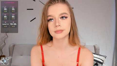 Media: Video of a young Caucasian woman with fair skin, long blonde hair, blue eyes, wearing a red bra, standing in a modern bedroom with a digital clock showing 15:30.