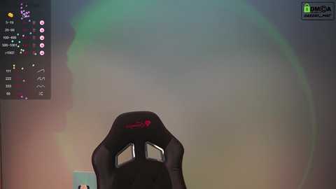 Media: A video of a gaming setup with a black gaming chair, a glowing green screen, and a monitor displaying a game with various in-game elements.