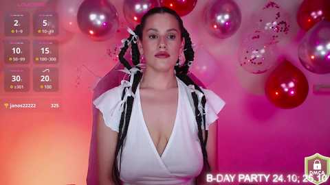 Media: A video of a woman with dark hair styled in twin braids, wearing a white V-neck top, against a pink and orange gradient background with balloons, marked as \"B-DAY PARTY 24.10.19\" in the bottom right corner.