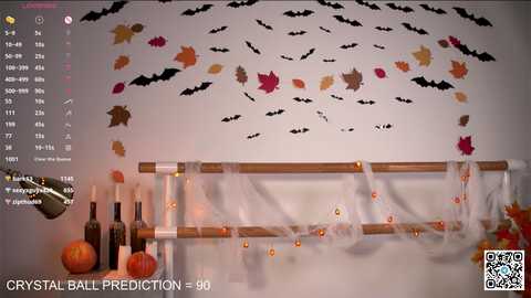 Media: Video of a Halloween-themed wall with bat and leaf decals, wooden wine rack adorned with pumpkins, and wine bottles.