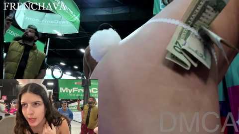 Media: A video of a woman's bare back with a large wad of cash stuffed into her bra, taken in a dimly lit, crowded room with green and white signage, including a \"FRANCE 2\" logo.