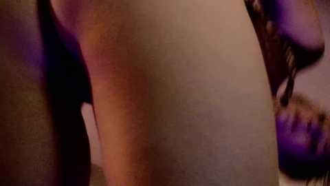 Media: Video of a close-up view of a woman's bare, pale buttocks, with a purple bra strap visible. Her face is partially blurred, suggesting intimacy and sensuality.