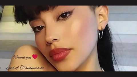 Media: Close-up video of an Asian woman with fair skin, long black hair, and dark eye makeup. She wears red lipstick and hoop earrings, with a blurred background. Text reads \"Thank you End of Fransmission.\