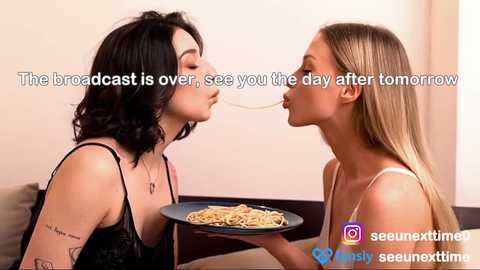 Media: A video captures two young women, one with dark hair and the other with blonde hair, sharing a spaghetti strand. The background is minimalistic with text overlay, \"The broadcast is over, see you tomorrow.\