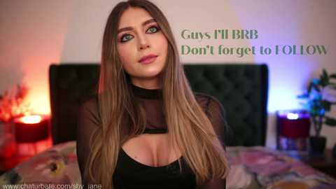 Media: A video of a young woman with long, straight, blonde hair, wearing a black, sheer top, standing in a dimly lit bedroom. Text overlay reads, \"Girls-Only BRB Don't forget to FOLLOW.\