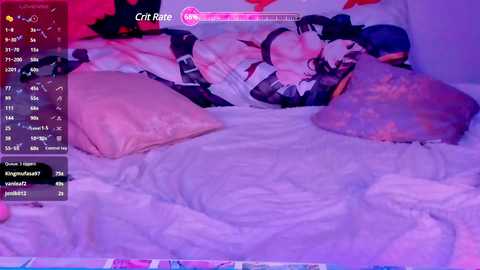 Media: A video of a young woman lying on a bed, wearing a black and white maid outfit. The room is dimly lit with a purple glow, pillows and a plush toy are scattered around.