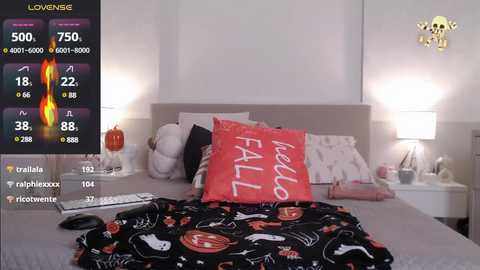 Media: A video of a modern bedroom with a white bed, two lamps, a red pillow with \"hello fall\" text, and a black blanket with Halloween patterns. A live stream display shows weather data on the left.