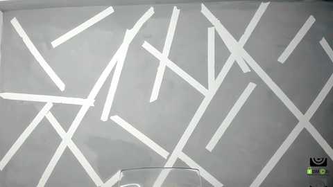 Media: A video of a minimalist, abstract wall art featuring numerous white, diagonal lines crisscrossing over a grey background. The lines create a dynamic, geometric pattern. In the bottom right corner, there's a small, black logo.