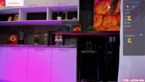 Media: Video of a modern kitchen with white cabinets, purple LED lighting, black countertops, and a vibrant orange pumpkin-themed wall decal.